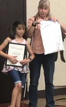 Photo of a blind teacher giving an award to her blind student.